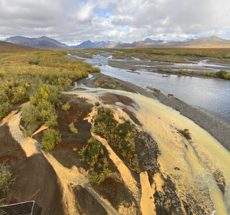 pale orange river flowing into a clear blue river.