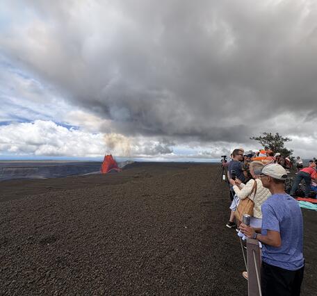 Color photograph of people viewing a volcanic eruption 