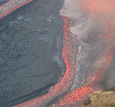 Color photograph of lava channel flowing during eruption