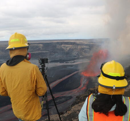 Color photograph of scientists monitoring eruption