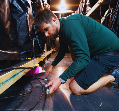 USGS Rob Anthony sets up equipment in a freezer to test a Seismometer.