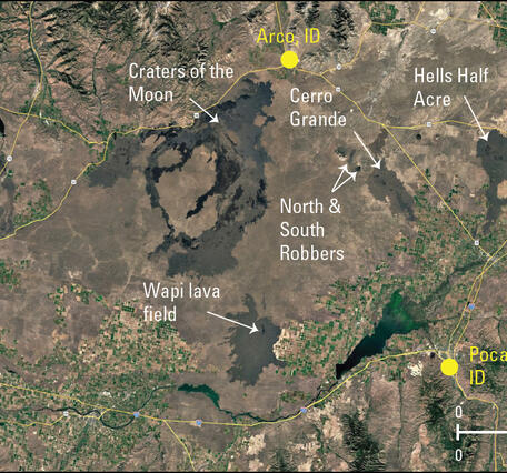 satellite image with agricultural areas and highways and isolated patches of lava flows from recent eruptions in Idaho