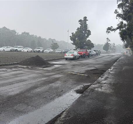 Color photograph of a pile of volcanic fallout that was cleared from roadway