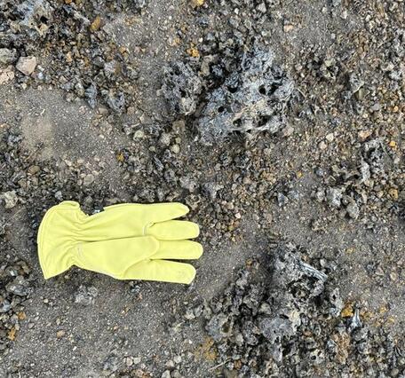 Color photograph of glove on ground