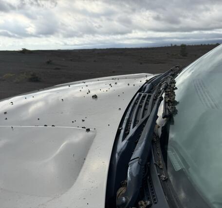 Color photograph of volcanic material on car