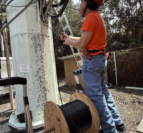 Color photograph of field engineer checking cables