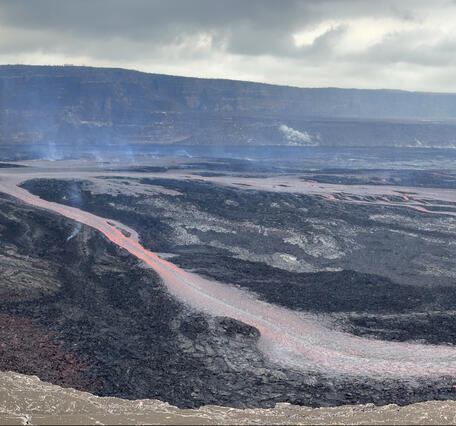 Color panoramic photograph of lava fountain and lava channel within volcanic crater