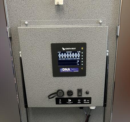 An open eDNA autosampler device "box" showing the control console and inside mechanisms