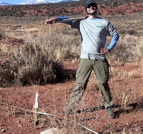 Jackson Sharp (USGS) at site visit with mountains in background