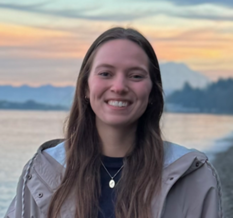 Smiling person with seashore, mountains, and sunset