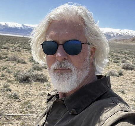 White man with white hair and black sunglasses