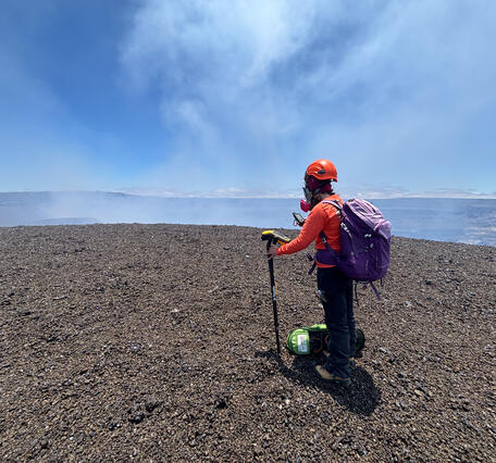 Color photograph of scientist measuring volcanic deposit