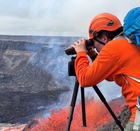 Color photograph of scientist monitoring volcanic eruption
