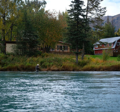 Homes and a fisher along the Kenai River.