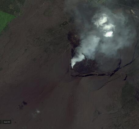 Satellite image of the summit of a volcano showing a caldera and volcanic gas plume