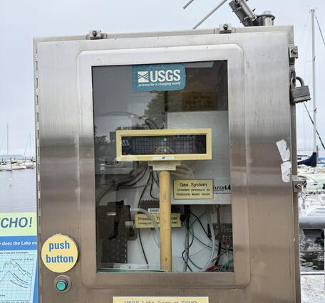 A USGS streamgage in a metal box with a clear door.