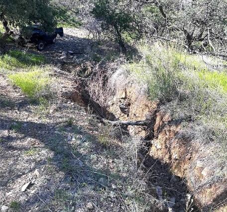 Figure 2. Photographs around the Santa Margarita Ranch including, a) USGS scientists investigating vertical-walled crack from degraded earthen berm; b) vibrant desert landscape featuring a "carpet" of golden Mexican Gold Poppies and purple Coulter's Lupine blooming among rocky soil and sparse vegetation; c) incising narrow, eroded gully or wash cutting through a dry, hilly landscape, and; d) desert arroyo (also known as a dry wash), characterized by a deep, eroded gully carved into the sandy, arid soil, wit