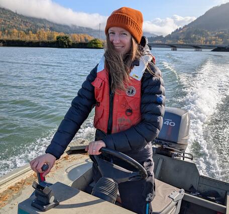 woman driving USGS boat in orange beanie