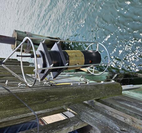Dropping a sensor into water from a dock.