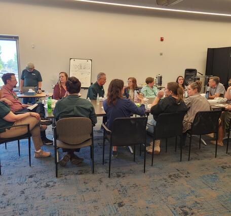 Photo of a lunchtime meeting where discussions are directed to Leadership.