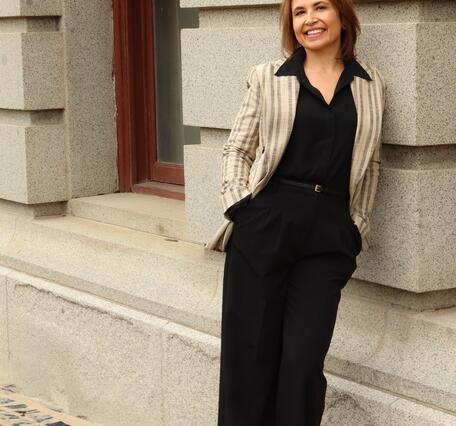 Melissa Schaar staff profile, leaning on side of building 