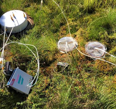 Scientific sampling equipment laying in grassy field.