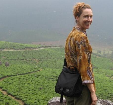 woman looking over her shoulder, terraced green fields in background