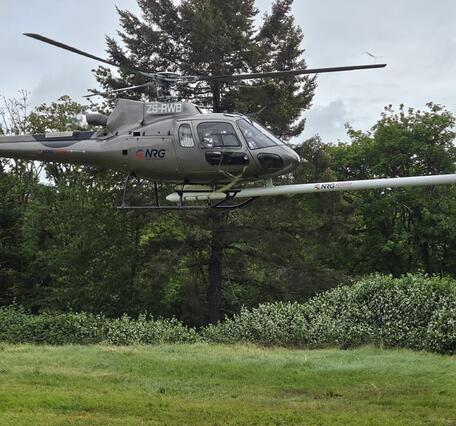 helicopter with front-mounted stinger containing equipment for conducting airborne geophysical surveys.