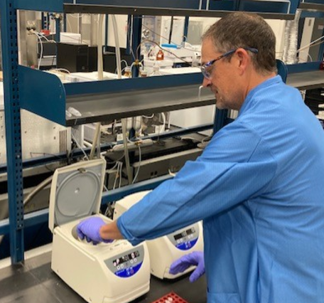chemist putting samples into centerfuge