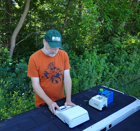 A person using testing equipment placed on a lowered truck tailgate