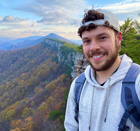 Image of Nicholas Giro with a mountain range behind him for his staff profile.