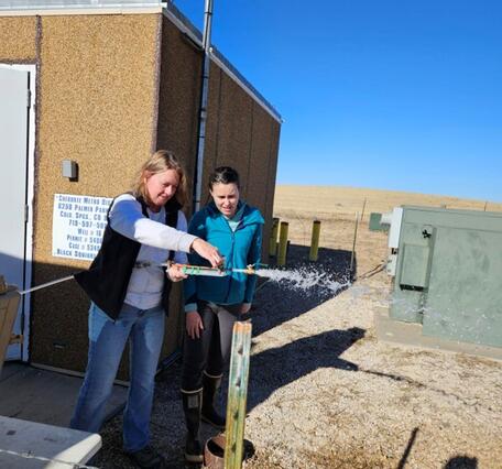 Photo of USGS employees creating back pressure at a production well
