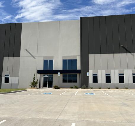 large, new building with blue sky in the background. The building is white, tan, and brown.