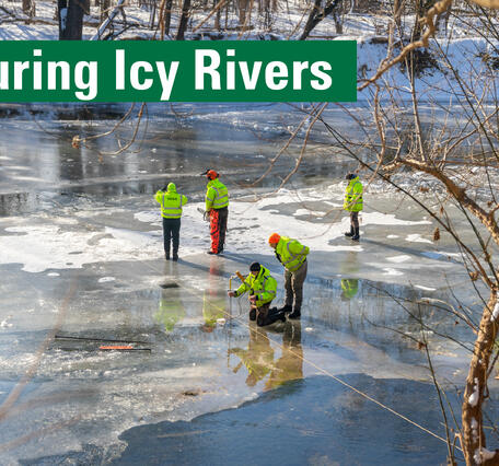 Six people wearing high visibility and protective gear stand on an icy river. Text reads: Measuring Icy Rivers.