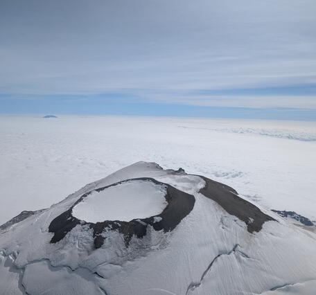 Color photos of the summit of Mount Rainier with snow on the mountain and clouds below.