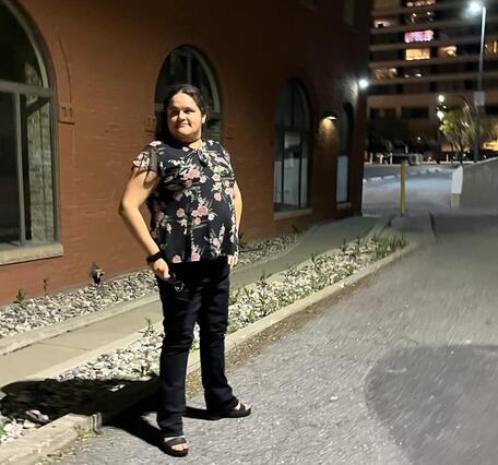 Women in front of building at night.
