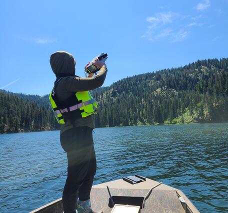 USGS scientist using spectral radiometer to measure light from boat on Fernan Lake, Idaho