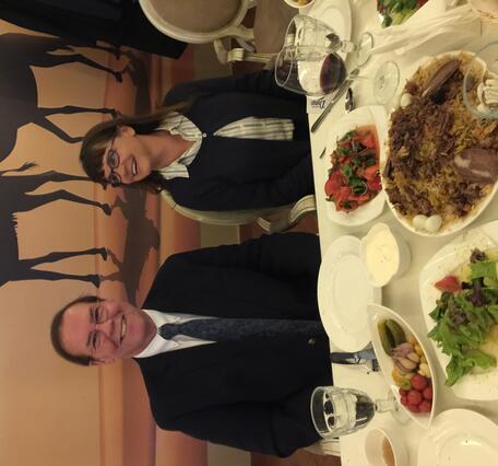 Man and woman siting at a dinner table in front of plates of food