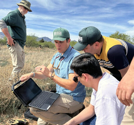 USGS staff demonstrate to Uzbek researchers the process of collecting and recording USGS groundwater data.