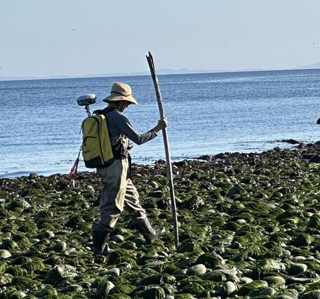 Picture of surveyor equipped with survey equipment during mapping mission
