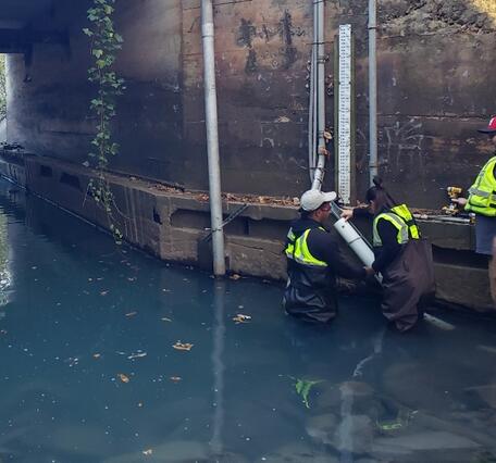 Scientists installing sensor in river
