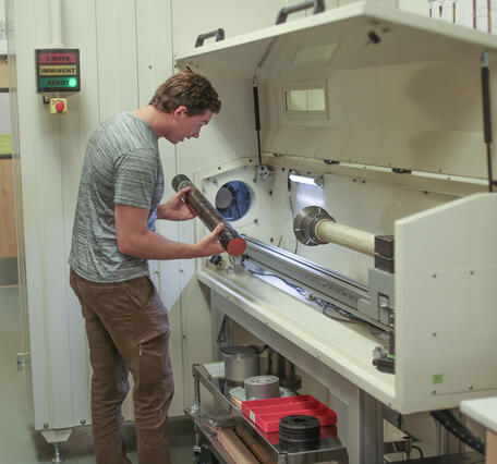 Scientist placing a sediment core in the rotating x-ray computed tomography system