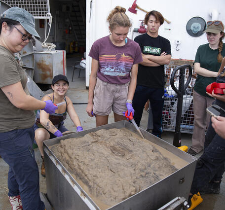 Scientists removing top water from a box core sample during the Hawaii Abyssal Nodules Expedition
