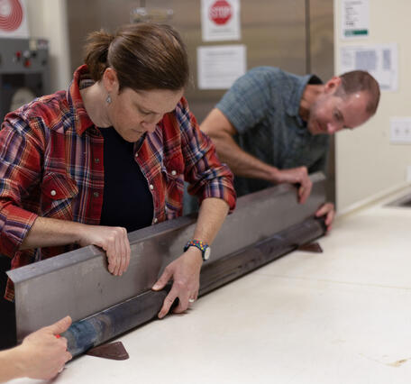 Scientists separating a sediment core split lengthwise