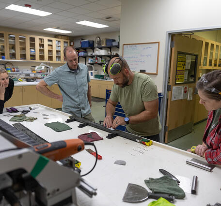 Scientists separating a sediment core split lengthwise