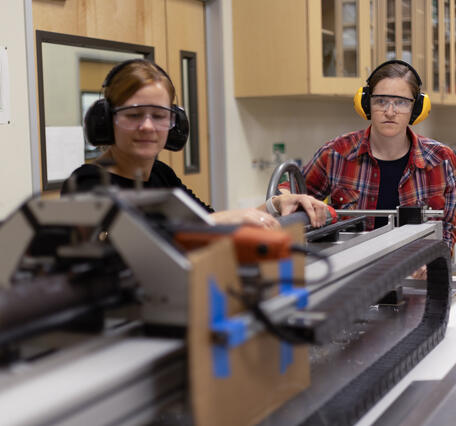 Scientists splitting a sediment core with the GeoTek core splitter