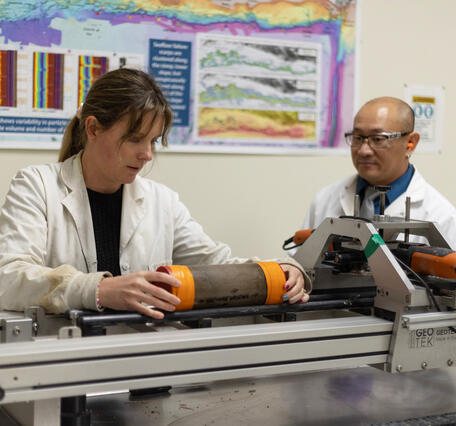 Scientists splitting a sediment core with the GeoTek core splitter