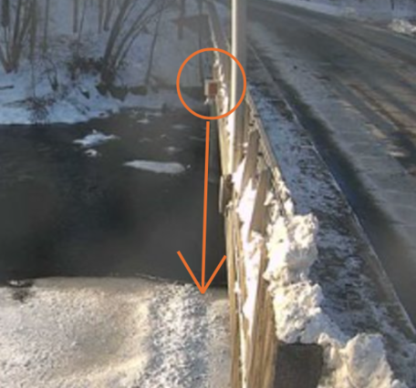 Partially frozen river flows under a USGS radar gage 