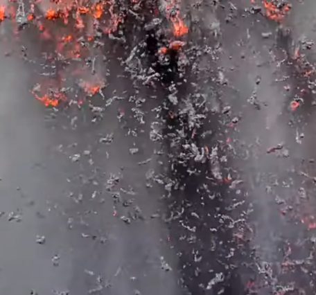 Color photograph of incandescent lava particles falling to the ground