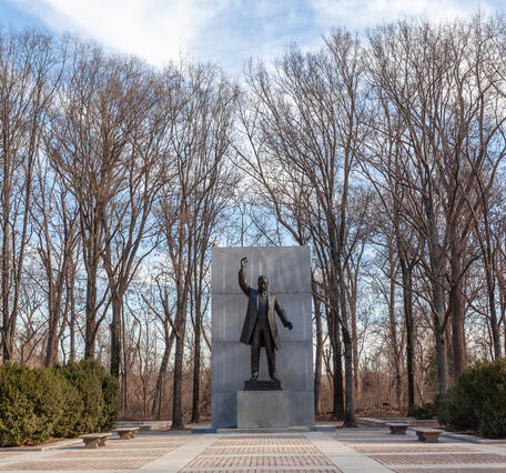 Theodore Roosevelt's statue has his right hand raised and he is standing as if he is speaking to a crowd.